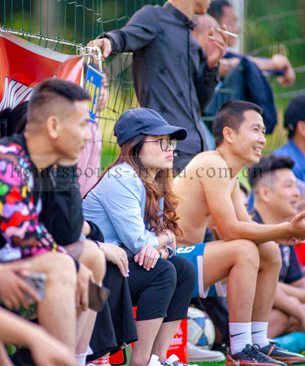 夜场看台上的人群剪影与球场灯光，纵向构图，不出现可辨面部